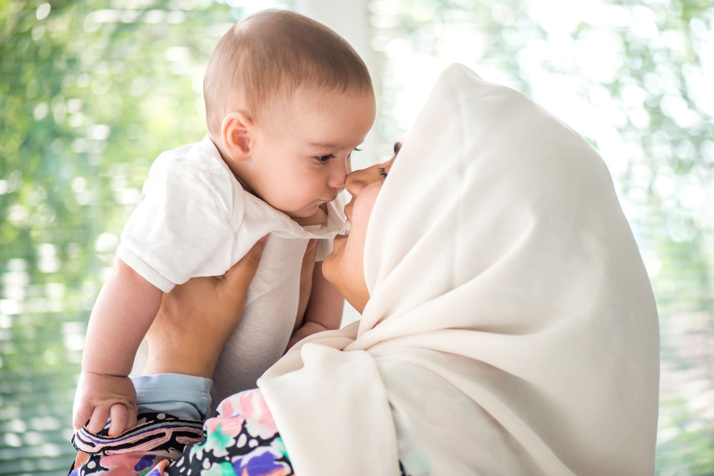 woman touching noses with baby